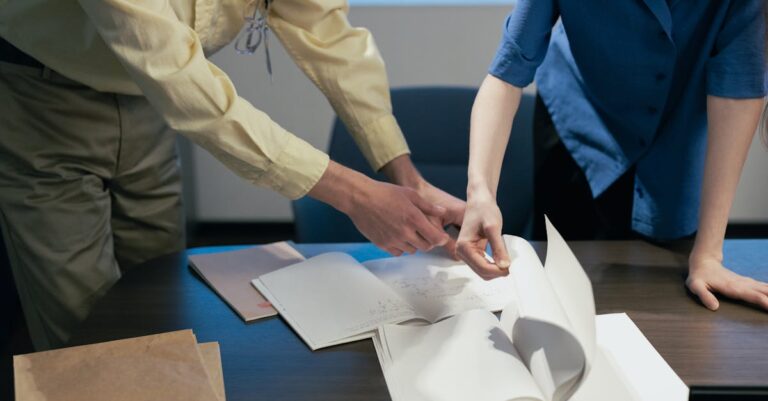 Dois pesquisadores revisando documentos juntos em mesa limpa com foco sério