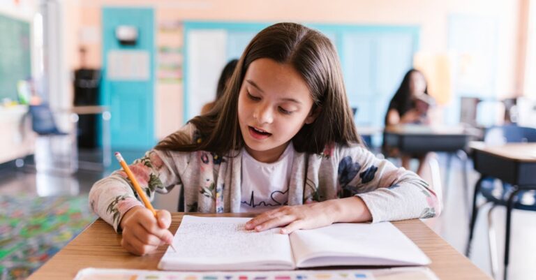 Pesquisador acadêmico celebrando progresso na escrita com laptop e notas em mesa limpa