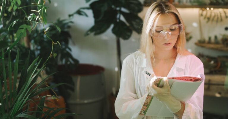Estudante pesquisadora escrevendo anotações em notebook com concentração, iluminação natural
