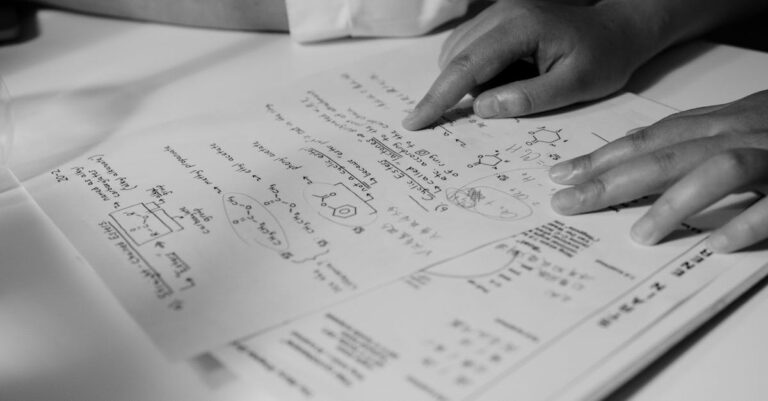 Pesquisador analisando papéis acadêmicos em escritório claro com fundo minimalista