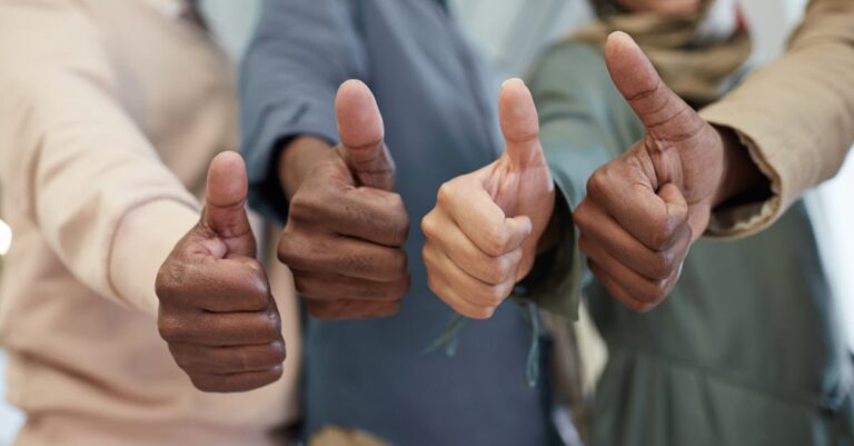 Pesquisador confiante segurando tese aprovada em mesa com luz natural