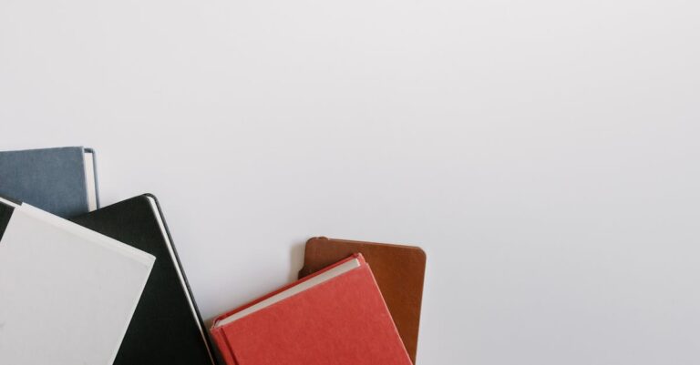 Pesquisador escrevendo objetivos de pesquisa em caderno aberto sobre mesa minimalista.