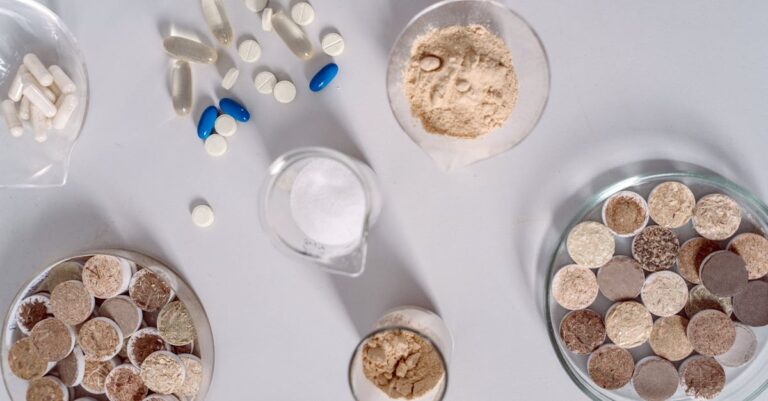 Pesquisadora escrevendo síntese crítica em notebook com papéis ao lado