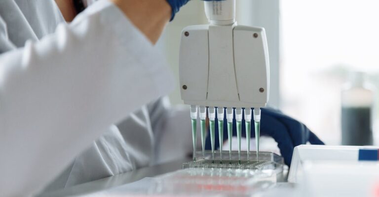 Pesquisador sintetizando dados em tabela padronizada em ambiente de trabalho iluminado