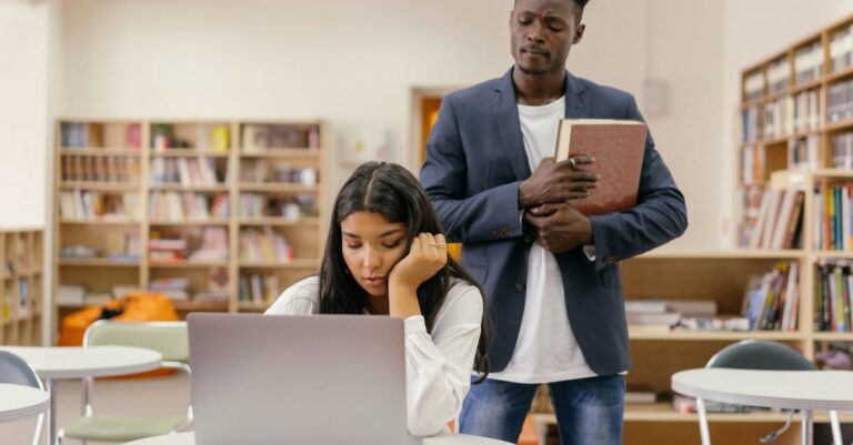 Pesquisador discutindo papéis acadêmicos com orientador em ambiente profissional claro