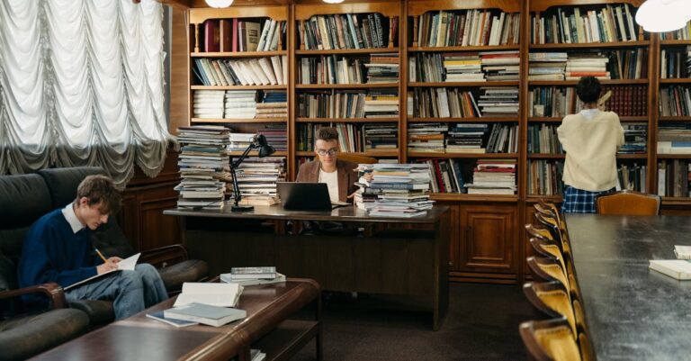 Pesquisador sorrindo confiante com laptop e papéis acadêmicos em mesa limpa iluminada naturalmente