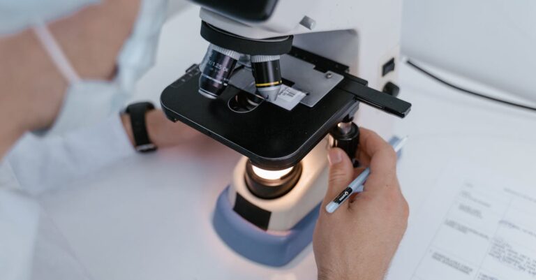 Pesquisador em momento de insight acadêmico, olhando para laptop com expressão de realização