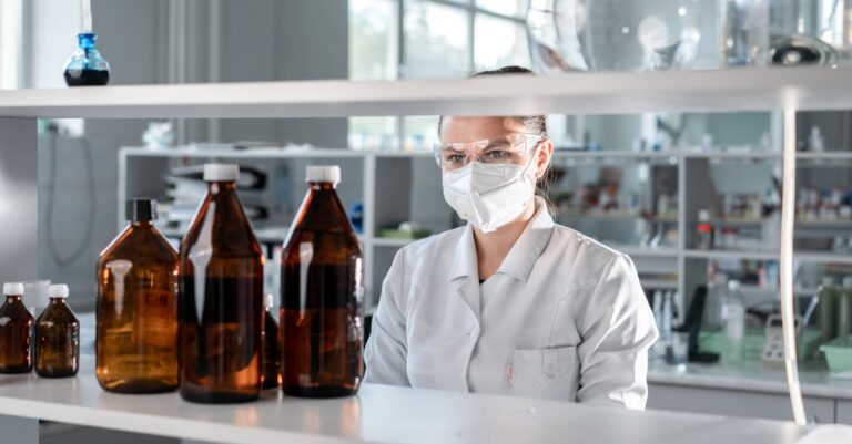 Cientista em escritório claro planejando projeto com notas e laptop