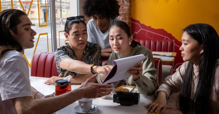 Grupo de pesquisadores discutindo em mesa com papéis e laptop em ambiente iluminado